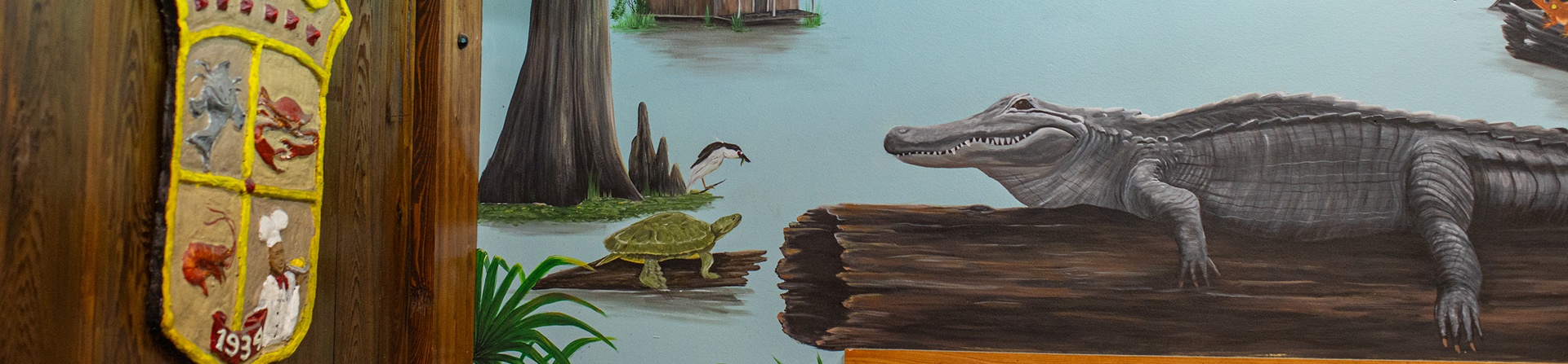 A painted mural shows an alligator and a turtle on logs in a swamp; a wooden wall with a decorative shield is on the left side of the image.